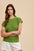 Annie Wear Round Neck Short Sleeve Sweater in green, styled with white shorts, showcasing ribbed texture.