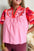 Embroidered notched short sleeve babydoll blouse in pink and red tones.