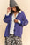 Davi & Dani shawl collar ribbed detail button-up cardigan in purple, styled with a beanie and printed skirt.