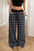 Plaid wide leg pants with drawstring, 100% polyester, styled for casual wear.