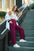 Umgee full size drawstring wide leg pants with pockets in burgundy worn by a woman on stairs.