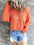 V-Neck drop shoulder knit top in orange with exposed seam and slightly stretchy fabric.