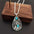 Alloy artificial turquoise teardrop pendant necklace on a display stand.