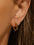 18K gold-plated stainless steel huggie earring on ear.