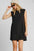 Umgee Round Neck Sleeveless High-Low Curved Hemline Mini Dress in black, worn by model.