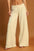 Umgee Elastic Waist Wide Leg Pants in beige on a model, showcasing the comfortable fit and flowy silhouette.