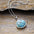 Turquoise chain pendant necklace with round stone detail.