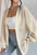 Open front long sleeve cardigan in cream, paired with white top and jeans.