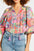 Printed tie neck three-quarter sleeve blouse in vibrant floral pattern.