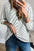 Striped V-neck long sleeve blouse in white with black stripes, worn with jeans.