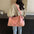 Large pink polyester travel bag with detachable crossbody strap.