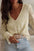 Lace detail V-neck long sleeve blouse in light color with semi-sheer design and slightly stretchy fabric.