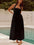 Devine Ruched Halter Neck Midi Dress in black by a poolside.