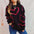 Heart pattern long sleeve sweater with pink hearts on black fabric.