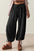 Drawstring ruched pants in black with elastic waistband and wide legs.