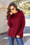 Basic Bae Full Size Ribbed Round Neck Long Sleeve Knit Top in red, worn by a model outdoors.