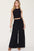 Basic Bae full-size ribbed tank and wide leg pants set with frill design and pockets, modeled in black.