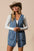 BiBi Braided Trim Open Front Denim Vest with pockets worn by a woman.