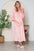 Full size pocketed hooded midi lounge dress in pink worn by a woman.