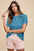 Annie Wear Round Neck Short Sleeve Sweater in blue worn with pink shorts.