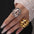 Stainless steel cutout ring with 18K gold plating displayed on fingers.