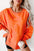 Side slit round neck long sleeve sweatshirt in orange, featuring exposed seam and slightly stretchy fabric.