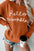 Letter graphic round neck long sleeve sweater in orange with "hello pumpkin" text.