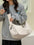 Oxford cloth large capacity crossbody bag in beige worn by person.