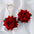 Alloy Rose Dangle Earrings with vibrant red rose design and delicate metal detail.