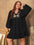 Plus size embroidered tie neck long sleeve mini dress in black.