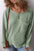 Plus size ribbed round neck long sleeve top with pocket in green.