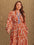 Plus size printed notched long sleeve maxi dress in orange and white pattern.