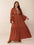 Plus size ruffled notched long sleeve midi dress in rust, featuring ruffles and a smocked design, crafted from 100% viscose.